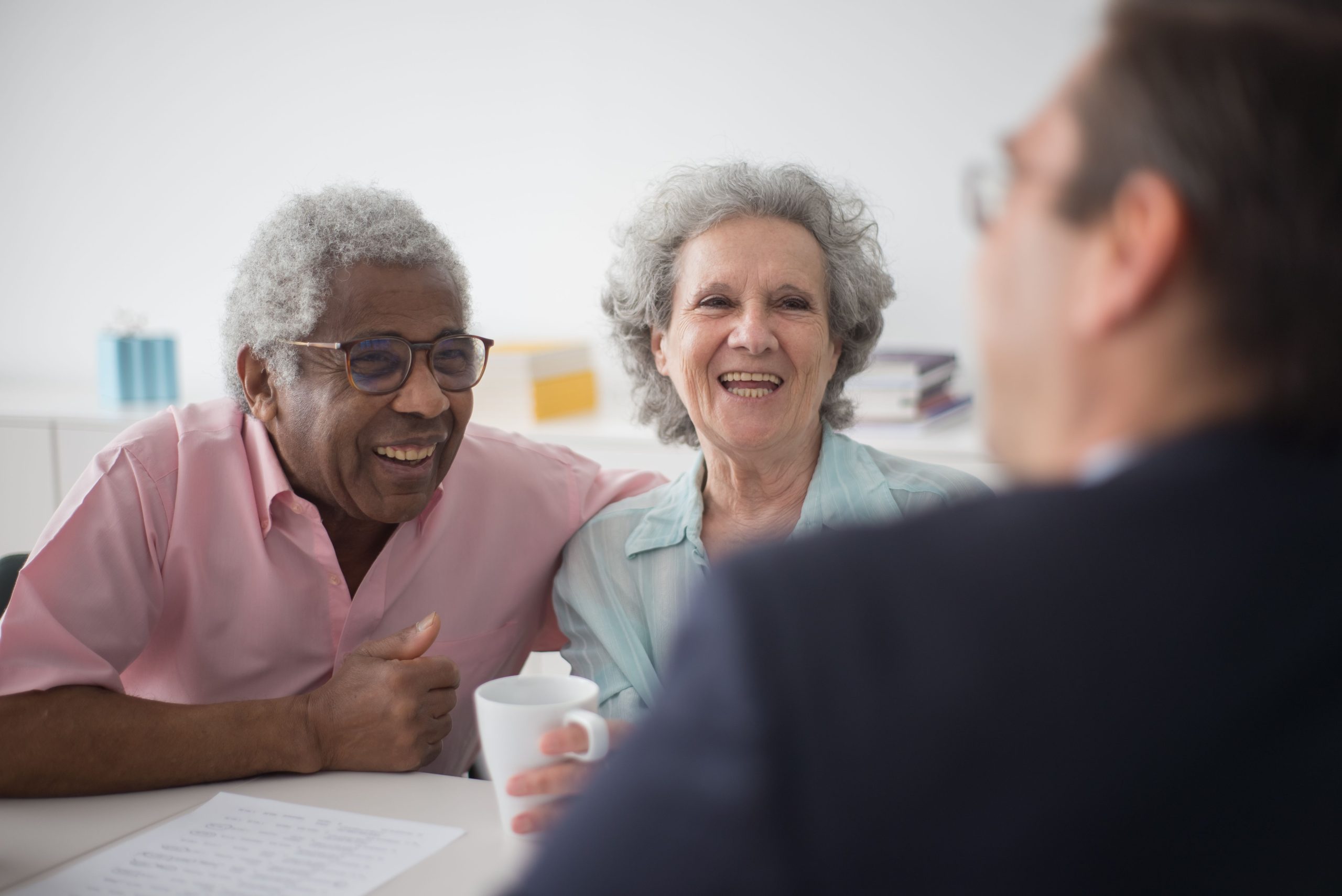 two seniors laughing over coffee