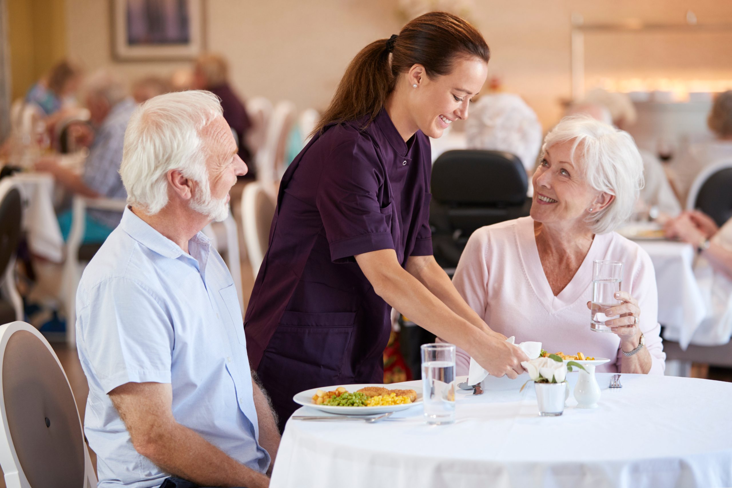 senior couple in dining hall smiling